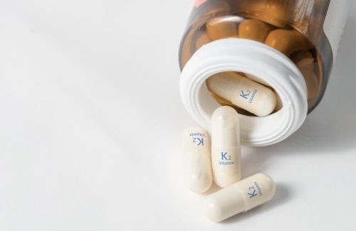 vitamin K2 supplements spilling out of a bottle