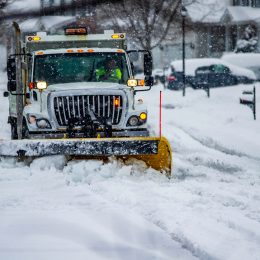 Heavy equipment driver working to push snow to the side of the streets after a blizzard