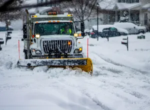 Heavy equipment driver working to push snow to the side of the streets after a blizzard