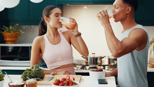 couple drinking smoothies in the kitchen