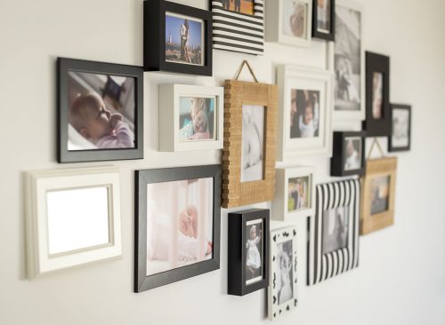 white wall with photos of the family in various photo frames