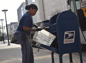 A postal worker emptying a mailbox