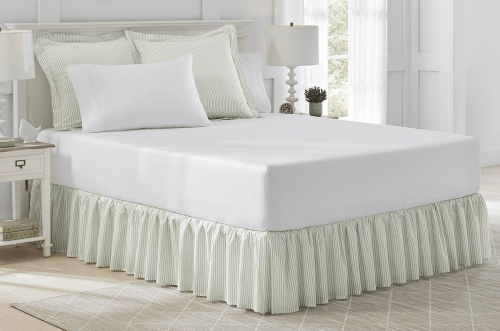 green and white striped bedskirt on bed