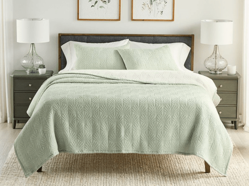 pale green woven quilt on bed