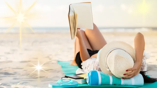 woman reading a book on the beach