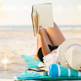 woman reading a book on the beach
