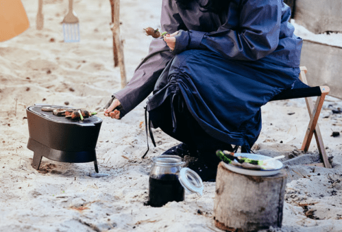 woman using small cast iron grill outside