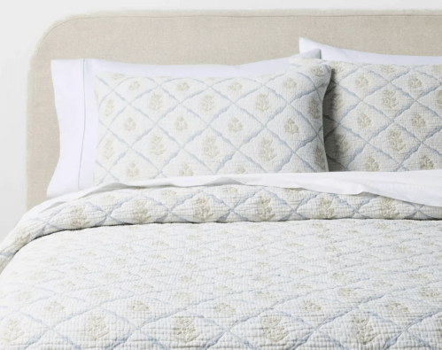light blue and green quilt set on bed