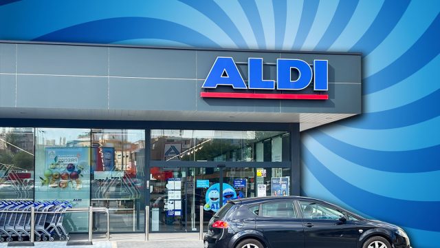9 Best New Aldi Finds Hitting Shelves in August. Alicante, Spain - May 27, 2025: ALDI store front displays modern design with a parked black vehicle and shopping carts, creating a lively shopping atmosphere