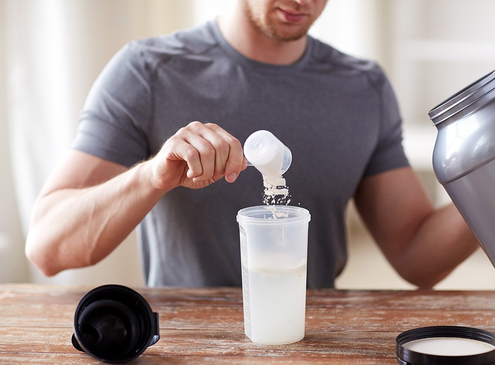 Man putting a powder into a drink shaker