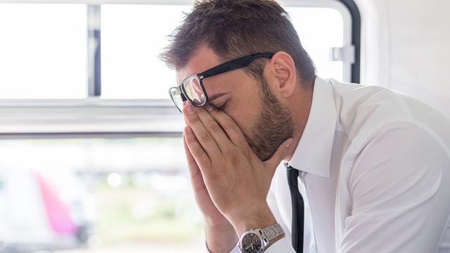 man stressed out and depressed on public transportation.