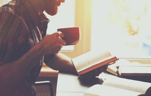 intelligent-man-reading-book-drinking-coffee