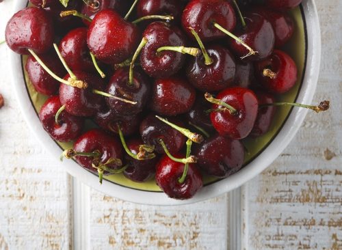 Cherries in a bowl on a wood background