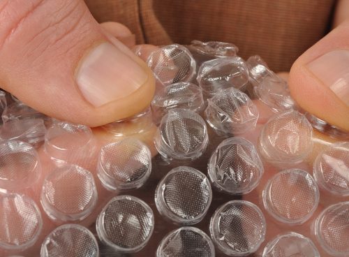 person popping bubble wrap