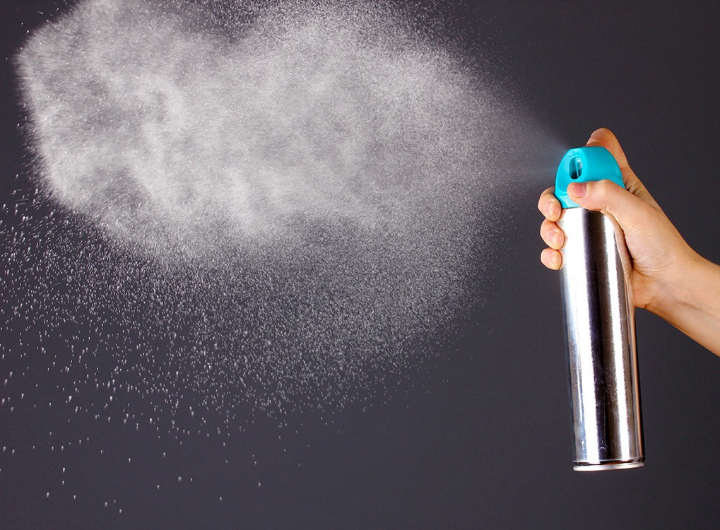 person spraying an air freshener